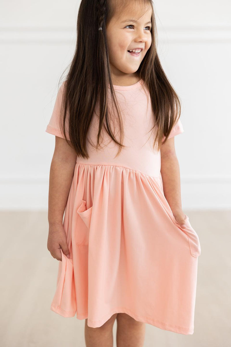 Kleid mit schwingendem Rock – Taschen, Pfirsichfarben, Kurzarm