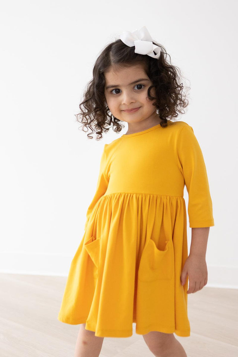 Kleid mit schwingendem Rock – Senfgelb, Taschen